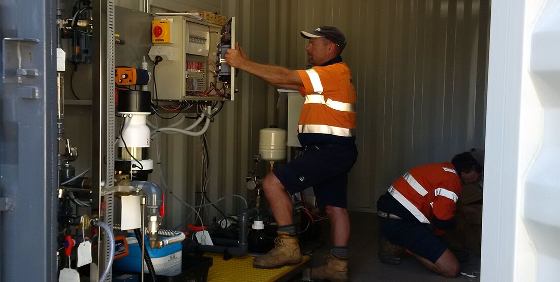mt-keira-judo-2 Service technician in water treatment plant room looking at control box