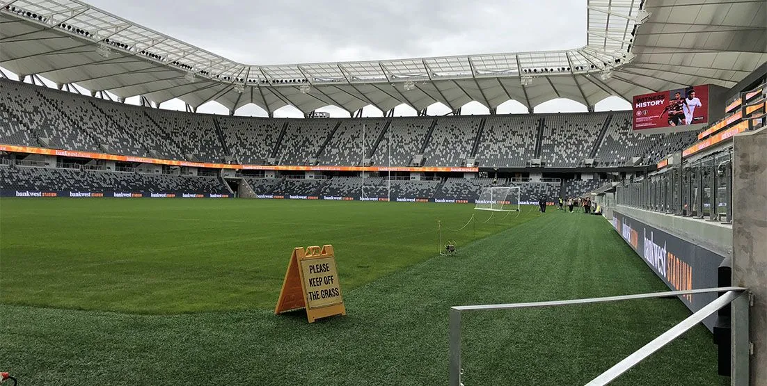 Photo of empty stadium taken from the bright green pitch.