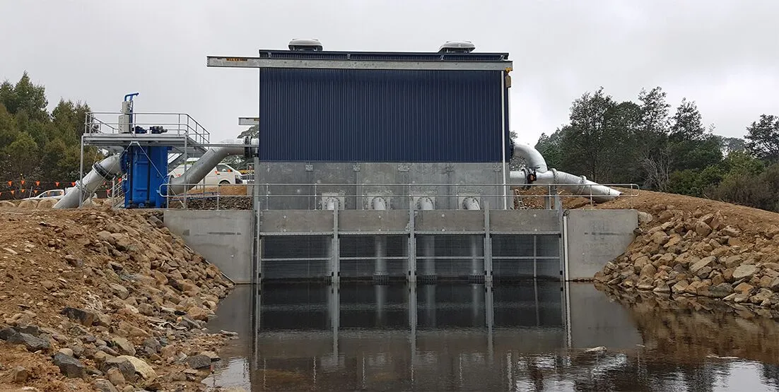 Outdoor photo of treatment plant, with water in front.